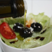 Salat Zubereitung mit Olivenöl, Oliven & Balsamico